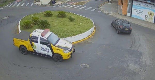 Motorista jogou carro contra policial antes de ser filmado dando voltas em rotatória para tentar fugir de abordagem no Paraná.